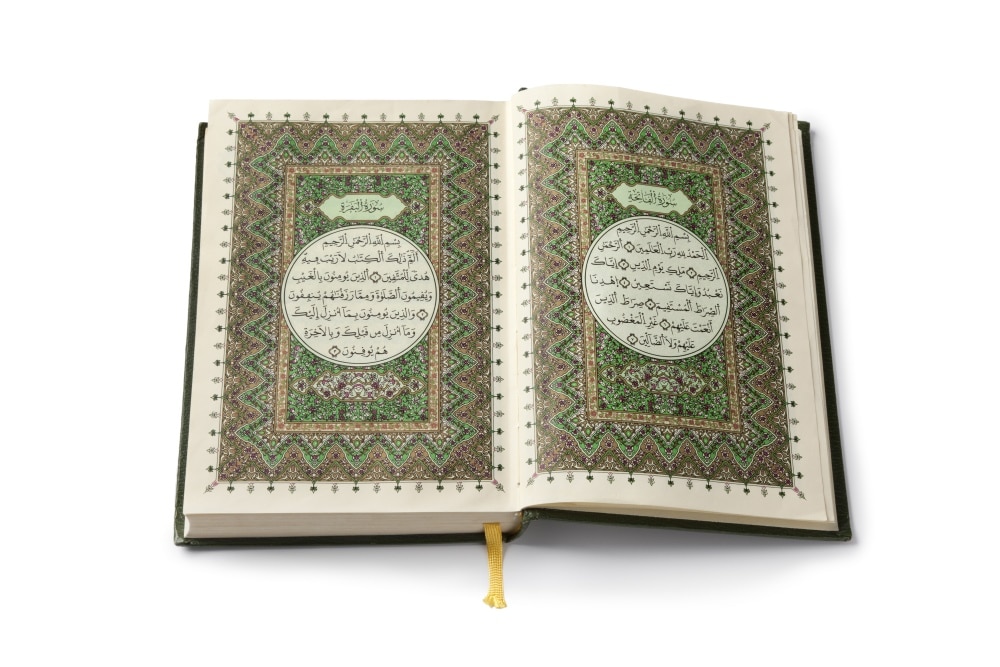 Open Koran book isolated on white background